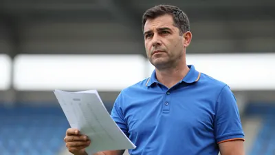 Middle-aged male manager, athletic build, mid-40s, waist-up in a plain blue shirt with orange trim, unmarked fabric...