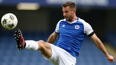 A tight action crop of an anonymous Oldham player, aged 25-30, wearing a blue jersey with white sleeves and a white...