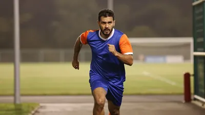 A 35-year-old, 5'10" athletic midfielder in mid-sprint, face set in fierce determination, blue cotton jersey with orange...