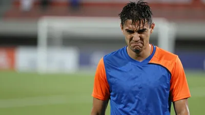 Mid-30s, lean midfielder, head-and-shoulders, eyes narrowed in frustration, short dark hair damp with sweat, jaw clenched