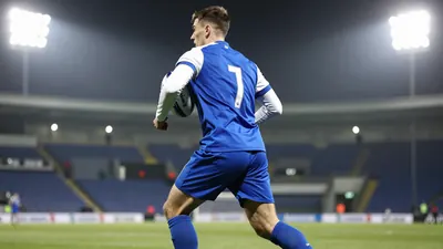 A photorealistic image of an anonymous Oldham player in a blue jersey with white sleeves and a white number on the back...