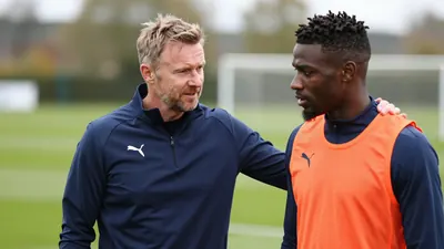 Gary Caldwell, Wigan Athletic boss, talking to Baba Adeeko during a pre-season training session at Mill Farm, with a...