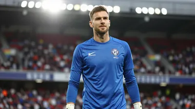 Photorealistic image of a 36-year-old goalkeeper in a solid blue kit, waist-up shot, standing confidently in a football...